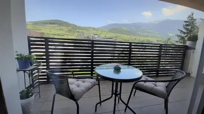 a table and chairs on a balcony with a view at Apartment Laura Brixen Vahrn in Varna