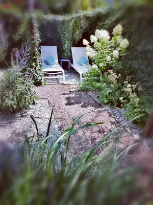 two white chairs sitting in a garden with flowers at Finesign 2 in Naturno
