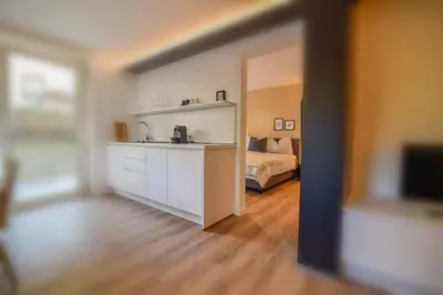 a room with a bedroom with a bed and a kitchen at Finesign 2 in Naturno