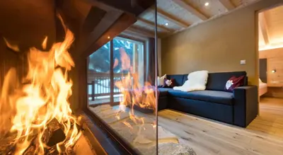 a fireplace in a living room with a blue couch at Unterkantiolerhof in Funes