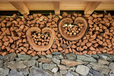 a stone wall with two hearts made out of logs at Ferienpension Zummüllerhof in Naz-Sciaves