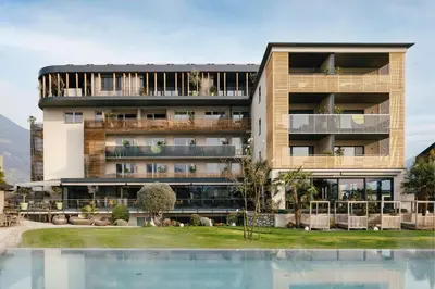 a building with a swimming pool in front of it at Hotel Pfeiss in Lana
