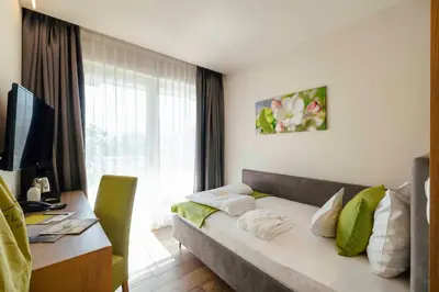 a hotel room with a bed and a desk and a window at Hotel Pfeiss in Lana