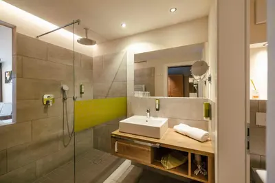a bathroom with a sink and a shower at Hotel Pfeiss in Lana