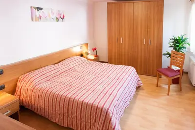a bedroom with a bed and a chair and a cabinet at Casa al Moro in Rocca Pietore