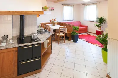 a kitchen and living room with a red couch at Casa al Moro in Rocca Pietore