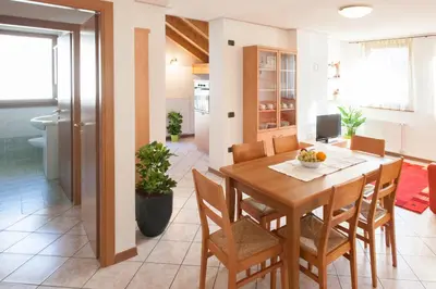a dining room and living room with a table and chairs at Casa al Moro in Rocca Pietore