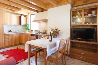 a kitchen with a table with chairs and a television at Casa al Moro in Rocca Pietore