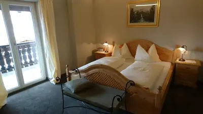 a bedroom with a bed with white sheets and a window at Furggerhof in Tirolo