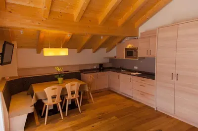 a kitchen with a table and chairs in a room at Residence Armonia in Colfosco