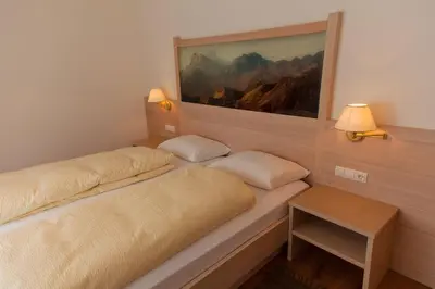 a bedroom with two beds and a painting on the wall at Residence Armonia in Colfosco
