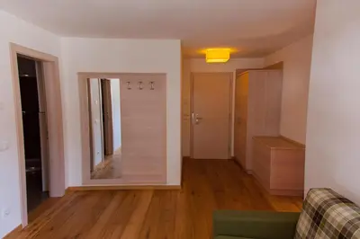 a living room with a mirror and a couch at Residence Armonia in Colfosco