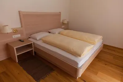 a bed in a room with a nightstand and a bed sidx sidx at Residence Armonia in Colfosco