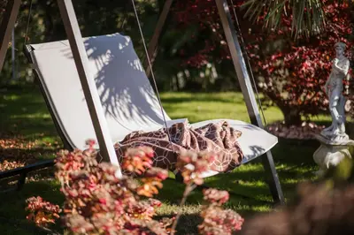 a chair with a blanket on it in the grass at Pension zum Burggräfler in Schenna