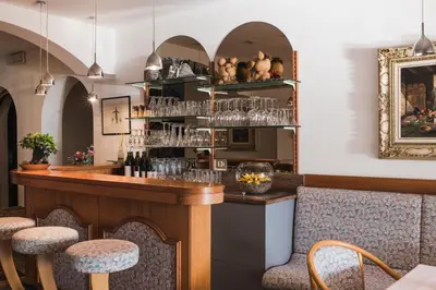 a bar in a restaurant with glasses on the shelves at Pension zum Burggräfler in Schenna
