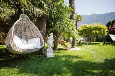 a hammock hanging from a tree in a yard at Pension zum Burggräfler in Schenna