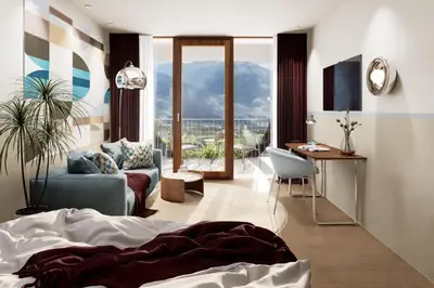 a bedroom with a bed and a living room at Pension zum Burggräfler in Schenna
