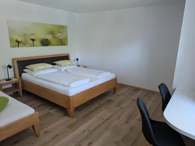 a bedroom with a bed and a table and chairs at Obermaratscher Apartments Residence in Lagundo