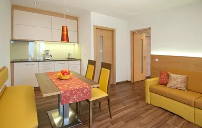 a kitchen and living room with a table and chairs at Obermaratscher Apartments Residence in Lagundo