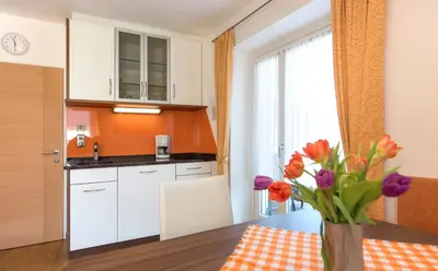 a kitchen with a table and a vase of flowers at Obermaratscher Apartments Residence in Lagundo