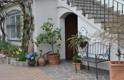 a black bench sitting in front of a house with plants at Obermaratscher Apartments Residence in Lagundo