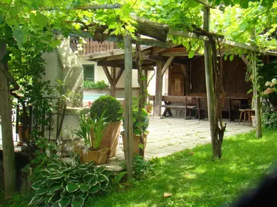 a garden with a wooden pergola and a table at Obermaratscher Apartments Residence in Lagundo
