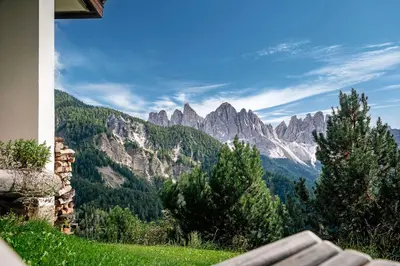 a view of a mountain range with a bench at Schopplhof - panoramic apartments dolomites in Villnoss
