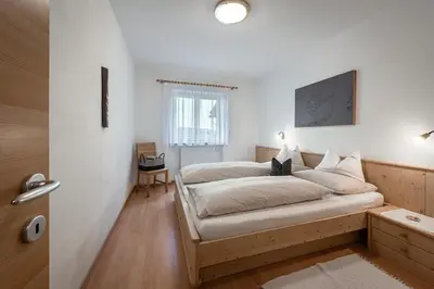 a bedroom with white walls and a large bed at Schopplhof - panoramic apartments dolomites in Villnoss