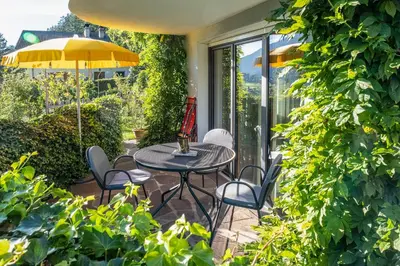 a patio with a table and chairs and an umbrella at Art Apartment Schatzer in Funes