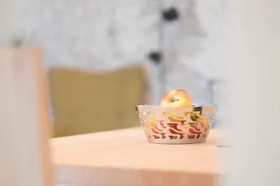 an apple in a bowl on a table at Art Apartment Schatzer in Funes