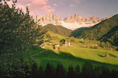 a valley in the mountains with a house and trees at Art Apartment Schatzer in Funes
