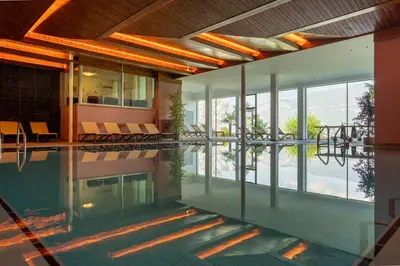 a house with a swimming pool with glass walls at Hotel Tenz in Montagna