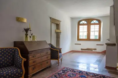 a room with a dresser and two chairs and a window at Schlosshotel Aehrental in Caldaro