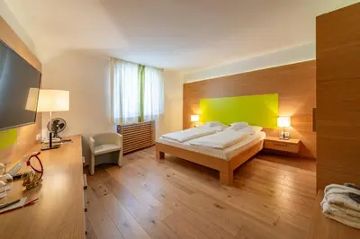 a bedroom with a bed and a green wall at Schlosshotel Aehrental in Caldaro