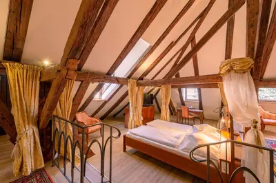 a bedroom with a bed in a attic at Schlosshotel Aehrental in Caldaro