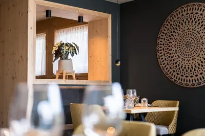 a mirror in a restaurant with a table and chairs at Hotel Sonnenheim in Chienes
