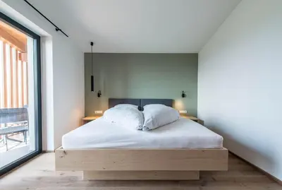 a bedroom with a bed with white sheets at Hotel Sonnenheim in Chienes