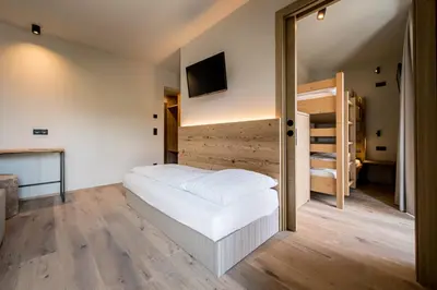 a bedroom with a bed and bunk beds at Hotel Sonnenheim in Chienes