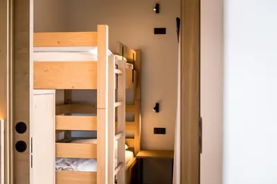 a small room with bunk beds and a closet at Hotel Sonnenheim in Chienes