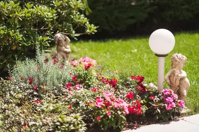 a garden with a lamp post and flowers at Residence Désirée Classic & Design in Merano