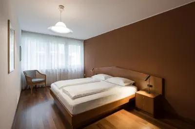 a bedroom with a bed and a chair and a window at Residence Désirée Classic & Design in Merano