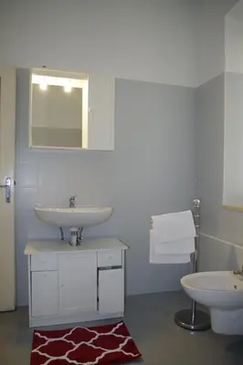 a bathroom with two sinks and a mirror and a rug at Da Francesca in Fiera di Primiero