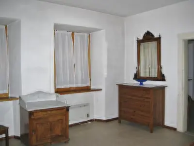 an empty room with a wooden dresser and a mirror at Da Francesca in Fiera di Primiero