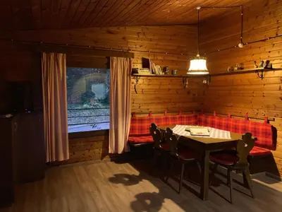 a dining room with a table and chairs and a window at Chalet San Valentino in Salorno sulla Strada del Vino