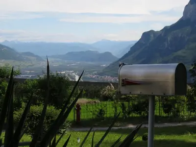 a mailbox in a field with mountains in the background at Chalet San Valentino in Salorno sulla Strada del Vino