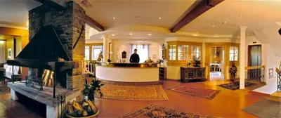 a man standing in a living room with a fireplace at Hotel Markushof 3***S in Valdaora