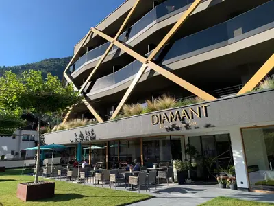 a building with tables and chairs in front of it at Genusshotel Diamant in Naturno