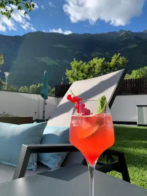 a drink on a table with a view of a mountain at Genusshotel Diamant in Naturno