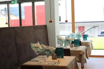 a dining room with two tables with white tablecloths at Genusshotel Diamant in Naturno