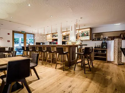 a bar in a restaurant with chairs and tables at Genusshotel Diamant in Naturno